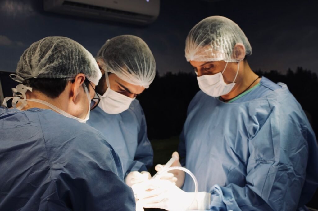 Equipe cirúrgica paramentada em centro cirúrgico durante cirurgia de implantes